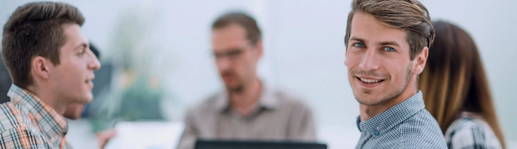 Junger Mann bei einem Meeting schaut in die Kamera, Copyright: ASDF - stock.adobe.com